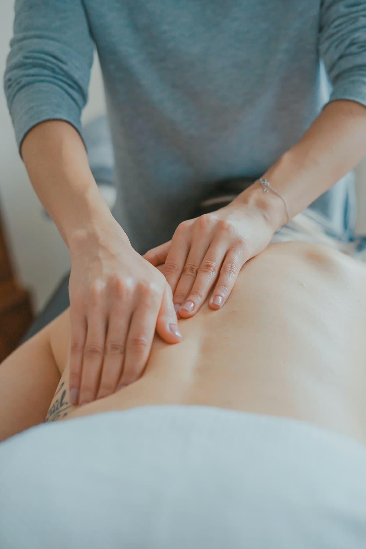 Practitioner performing hands-on structural bodywork on a patient's back